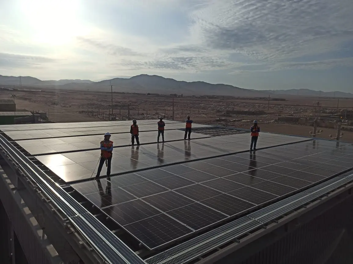 Cuadrilla sobre el techo de la planta solar de Antofagasta al amanecer